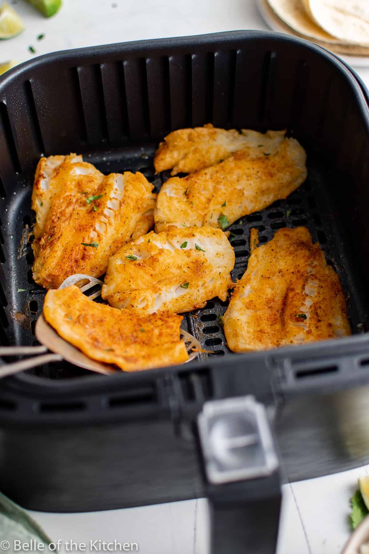 Pescado frito y crujiente en una cesta de freidora.