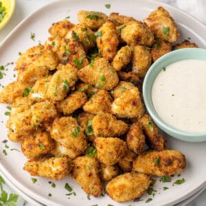 Nuggets de pollo en un plato junto a un plato de aderezo ranch.